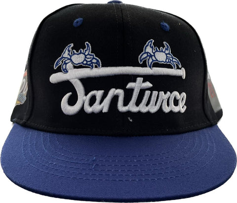A black and blue snapback hat with the text 'Santurce' and crab graphics embroidered on the front.