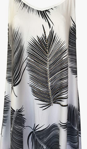 A chic white dress with bold black palm leaf patterns, featuring a sleeveless, asymmetrical hem design, ideal for a stylish tropical beach look.