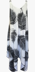 A chic white dress with bold black palm leaf patterns, featuring a sleeveless, asymmetrical hem design, ideal for a stylish tropical beach look.