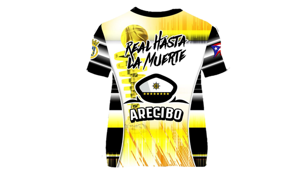 Front and back view of the 2025 Capitanes de Arecibo BSN basketball jersey, showcasing a yellow and black design with a ship wheel graphic, the team name 'Capitanes,' and the BSN logo. The back features 'Real Hasta la Muerte' text, 'Arecibo' lettering, a captain's hat emblem, and a Puerto Rican flag with the 'Gufao' mascot in the center.
