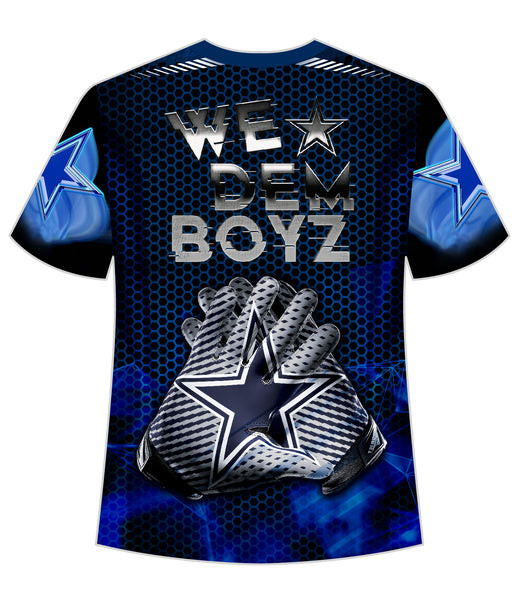 A striking blue t-shirt featuring the Dallas Cowboys logo with a prominent star and the team name "COWBOYS" in bold. The design includes a futuristic cityscape of Dallas with iconic buildings and a reflection on water, accented with hexagonal patterns and glowing blue star elements, perfect for NFL fans.