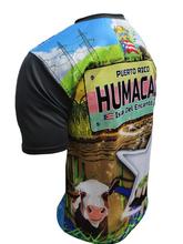 A vibrant t-shirt celebrating Humacao, Puerto Rico as "La Perla del Oriente" with front and back designs. The front features bold text "La Perla del Oriente" with a colorful flag collage, a coat of arms, and a blue gradient background with the Puerto Rican flag. The back showcases a rural landscape with cows, a "Humacao Isla del Encanto" sign, and a large star with a Gufeao logo, perfect for expressing Humacao pride and Puerto Rican heritage.