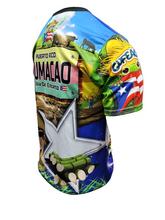 A vibrant t-shirt celebrating Humacao, Puerto Rico as "La Perla del Oriente" with front and back designs. The front features bold text "La Perla del Oriente" with a colorful flag collage, a coat of arms, and a blue gradient background with the Puerto Rican flag. The back showcases a rural landscape with cows, a "Humacao Isla del Encanto" sign, and a large star with a Gufeao logo, perfect for expressing Humacao pride and Puerto Rican heritage.