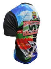 A vibrant t-shirt celebrating Jayuya, Puerto Rico as "La Capital Indigena" with front and back designs. The front features bold text "La Capital Indigena Jayuya" alongside indigenous Taino symbols, a coqui frog, sun emblem, and Puerto Rican flag elements on a blue gradient background. The back showcases a scenic mountain landscape with a "Jayuya Isla del Encanto" sign, Taino petroglyphs, and a Gufeao logo, perfect for expressing Jayuya pride and Puerto Rican indigenous heritage.
