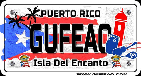 A stylized license plate with a distressed background featuring the Puerto Rican flag's blue triangle with white star and red stripes. The word "GUFEAO" is prominently displayed in large black letters, with "PUERTO RICO" above in red. Icons include palm trees, a red sentry box, a blue conga drum, and a guitar. Below, "Isla Del Encanto" is written in black, flanked by two "Gufeo" cartoon characters with flags. The website "www.gufeo.com" is at the bottom.