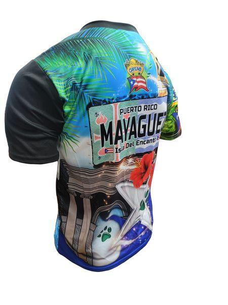 A design of a T-shirt with a front and back view. The front features "La Sultana del Oeste" in bold text, a bulldog, the Puerto Rican flag, and various international flags, with a "Gufeo" cartoon character and flag emblem. The back displays "Mayaguez" on a license plate-style graphic, a red hibiscus flower, a white star with a paw print, and the Puerto Rican flag, with a church and palm trees. The website "www.gufeo.com" is implied in the design context.