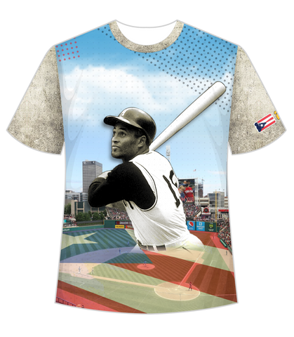 A stylish t-shirt featuring front and back designs honoring Roberto Clemente, a legendary baseball player. The front showcases Clemente in his batting pose against a stadium backdrop with a Puerto Rican flag, while the back displays his number 21 and name in bold, set against a distressed flag design.