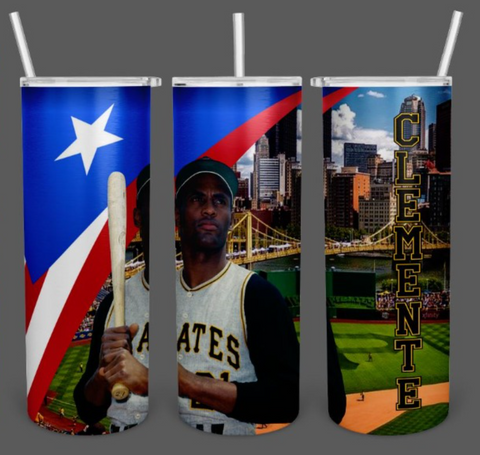 A tribute tumbler featuring Roberto Clemente, a legendary Pittsburgh Pirates baseball player, holding a bat. The design includes the Puerto Rican flag, a cityscape with a yellow bridge, and a baseball field, with 'Clemente' written vertically. Perfect for fans and collectors